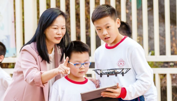 學生利用平板電腦操控無人機進行航空拍攝。