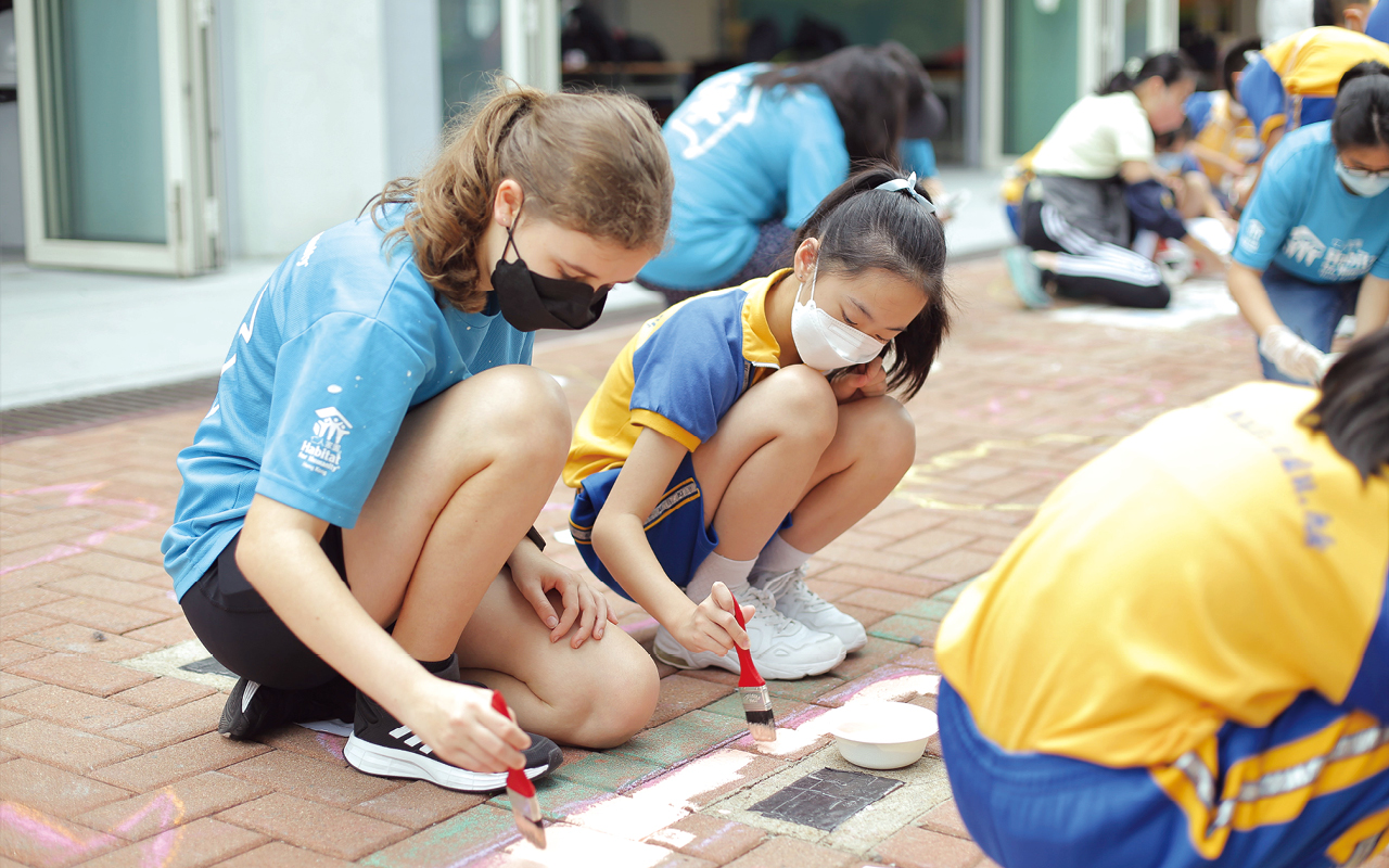 英文科組去年亦與慈善組織「香港仁人家園」合作，舉辦「繽紛校園藝術計劃」，邀請40位外籍及本地義工到校，與學生一同在學校的露天廣場以「Value our variety」及「Strength with Actions」繪畫長達17米的大型地畫，以表達辦學機構培育學生多元發展及價值教育的教學理念。